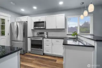 Granite counters, shaker style cabinetry, stainless appliances, recessed lighting, full tile back splash.