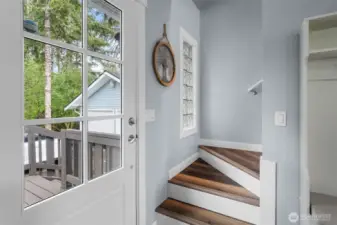 Staircase leading upstairs is right next to the front entrance and porch.