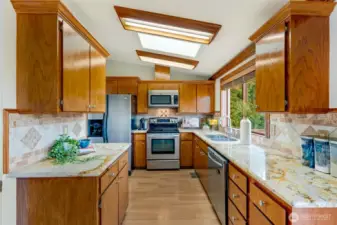 he kitchen overlooks the backyard, making it a perfect spot to prepare meals while staying connected with family or entertaining guests.