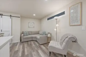 Spacious lower level suite with ample living space, dining area and a large closet featuring custom barn doors for added character.