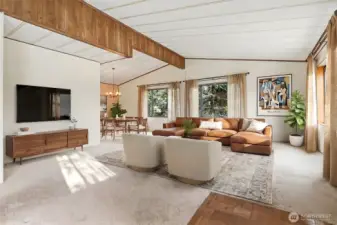 Living room with vaulted ceilings and picture window with a lake view opens to the dining room.  Virtually staged photo.