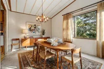 Formal dining room with vaulted ceilings, opens to the living room overlooking the lake.   Virtually staged photo