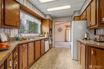 Spacious kitchen with plenty of counter and cabinet space and an eating bar opens to the family room.  Virtually staged photo