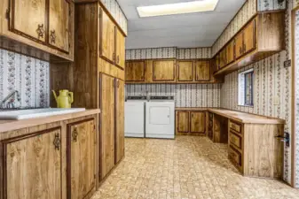 Huge utility room with full size washer and dryer, a utility sink and cabinets and counterspace galore. Opens to the atrium/greenhouse