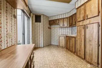 Huge utility room with full size washer and dryer, a utility sink and cabinets and counterspace galore. Opens to the atrium/greenhouse