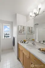 The main bathroom upstairs is spacious, with great counter space and storage plus an extra privacy wall!