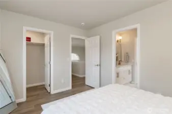 View of walk-in closet and door leading to bathroom.