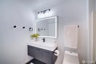 Updated bathroom with LED lit mirror and floating vanity.