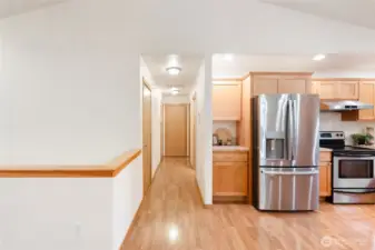 Hallway from the kitchen to the half bath, primary suite and garage.