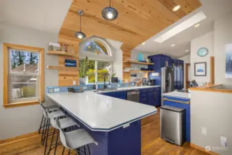 What a cheerful kitchen to cook in! Large breakfast bar with solid surface countertops. Beautiful wood accents.
