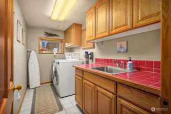 Laundry room has plenty of room with built in cabinets and a sink.