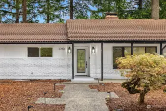 Modernized exterior black and white sets the tone for the entry to this lovely home, with staggered aggregate walkway, handsome Japanese maple and covered front patio leading to the stunning leaded glass front door.