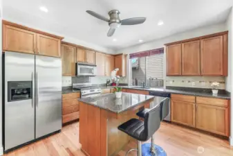 The kitchen features granite countertops, stainless steel appliances, and high ceilings.