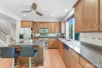 The kitchen features granite countertops, stainless steel appliances, and high ceilings.