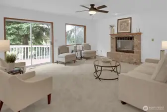 Spacious family room with stately brick fireplace & big sliding door leading out to the deck & backyard