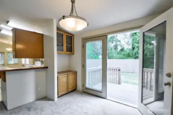 French doors off the dining area with another deck look out to the mature trees to the back of the home