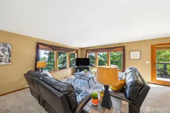 Walls of windows frame the view and the Autumn leaves.  The custom design of the home and quality finish work highlight the views and welcome each season into the main living spaces.