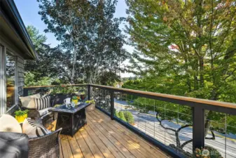 The original deck was removed and a remodeled, contemporary cedar deck with wire and wood railing was added.  Loads of space waits for your grill, container plants or cozy fire table to set the mood for Autumn revelry.