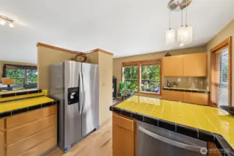 From the sink area enjoy walls of view windows filled seasonal color, instead of sidewalk activity.  A well-planned kitchen in which to explore your inner chef and loads of cabinet and shelf space to hold kitchenware.