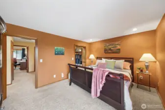A view of the spacious primary suite and the hallway to the 2nd full bath, laundry, and two more bedrooms.   The additional bedrooms enjoy separate walls from the primary bedroom.