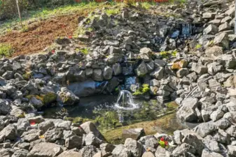 A landscaping waterfall feature beside the driveway beckons serenity and your favorite plantings.