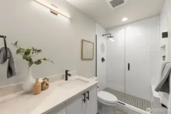 Primary suite carries luxury finishes, including rainfall shower head, 3cm quartz countertops, full tile surround and glass door entrance (photos are of 1108B, similar floor plans & finishes)