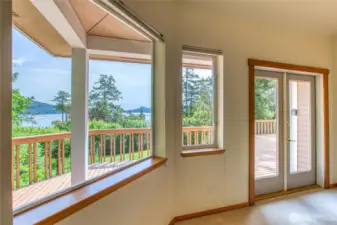 Primary bedroom suite is freshly painted with french doors, large windows, and vaulted ceilings.