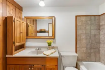 Full bathroom off second primary bedroom. Tile tub surround and flooring.