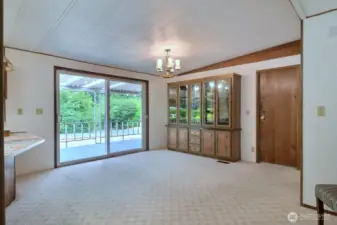 The open dining room sits in front of a sliding glass door overlooking the delightful yard. Lots of room here for large dining table and chairs for several dinner guests.