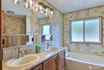 En-suite bath completes the primary suite with a large double sink vanity, soaking tub and walk in shower.