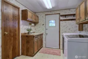 This well-organized laundry/mudroom combines practicality and thoughtful design featuring a utility tub for easy cleaning tasks and a generous array of cabinets for storing supplies out of sight.