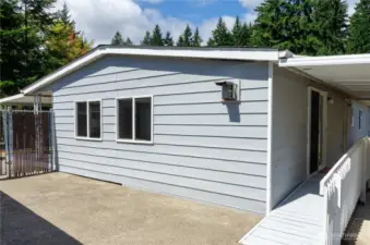 Fully fenced yard with side patio for outdoor entertainment.