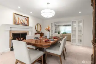 The dining room features a cozy gas fireplace, elegant chandelier, and glass doors opening to the covered patio