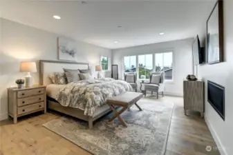 The primary bedroom has a see through fireplace and access to a Juliet balcony. Also has peekaboo views of Lake Washington.