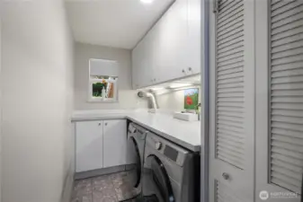 Laundry room with linen closet and more storage.