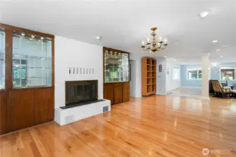 Dining Room with a fireplace that has an insert with a fan and a wood box cabinet next to it that you fill from the garage