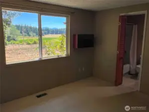 Large double window with a view of the Olympic Mountains and lovely landscape. Full bathroom en suite.