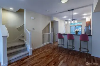 Great room looking back to the kitchen with granite eating bar.  Kitchen also has a pantry & room for a small table & chairs if desired.  (Virtually Staged)