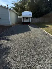 RV Parking with crushed gravel, Water hookup in the front of garage, and 30-amp hookup. Check out the large door opener made of carved wood-so unique.