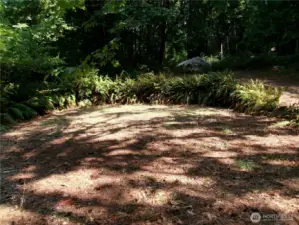 Lovely little circular spot nestled in between the turn-around driveway. Perfect spot for a picnic table, gazebo, or pleasure fire pit.