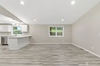 Living room off kitchen, featuring vaulted ceilings.