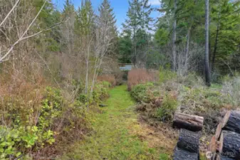 Maintained Walking trails snake throughout the back yard, leading to fire pit areas, a creek and a small clearing.