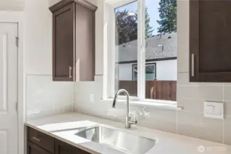 Window above kitchen sink to look out to the Mountains and large yard. Soft close drawers throughout home. Photo is representational. Actual home is under construction and finishes, and paint colors may vary. See site agent for details.