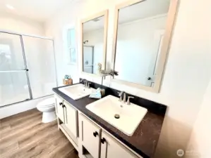 Stylish primary suite bathroom w/dual vanities and walk-in shower.
