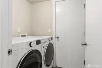 The utility room with a newer 2022 full-sized washer/dryer set that stays.
