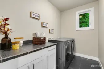 Large laundry room with storage on upper level.