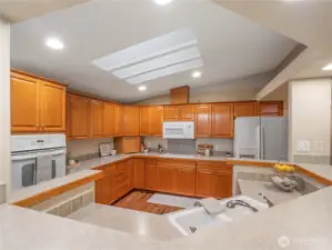 The kitchen features oak cabinetry with pull-out shelves and newer appliances.