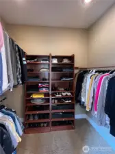Walk-in closet with more custom cabinetry.