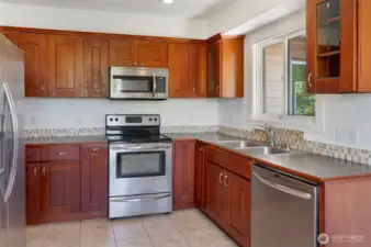 Open concept kitchen w/ wood cabinets and stainless steel appliances.