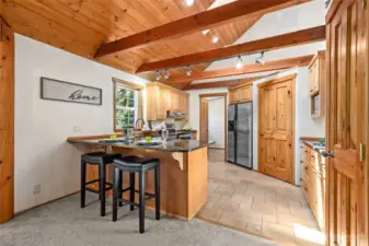 Chef’s kitchen, which features custom cabinetry, granite counters with breakfast bar, stainless steel appliances, and two pantries (including a walk-in!)